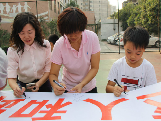 “甜甜姐”和孩子在社团条幅上签名3.jpg