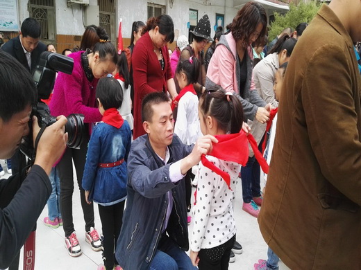 二七区京广路小学:家长为孩子佩戴红领巾2.jpg